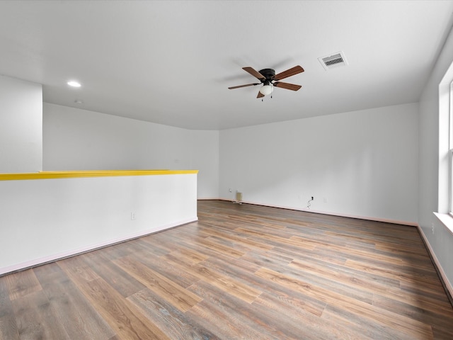 empty room featuring recessed lighting, a ceiling fan, visible vents, and wood finished floors
