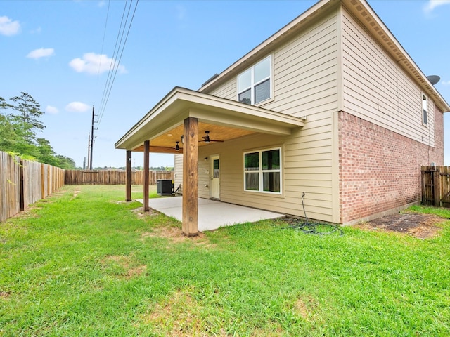 rear view of property featuring a patio area, ceiling fan, a yard, brick siding, and a fenced backyard