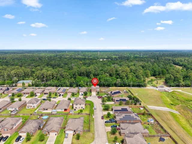 drone / aerial view featuring a residential view and a view of trees