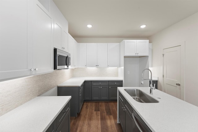 kitchen featuring recessed lighting, stainless steel appliances, light countertops, a sink, and white cabinetry