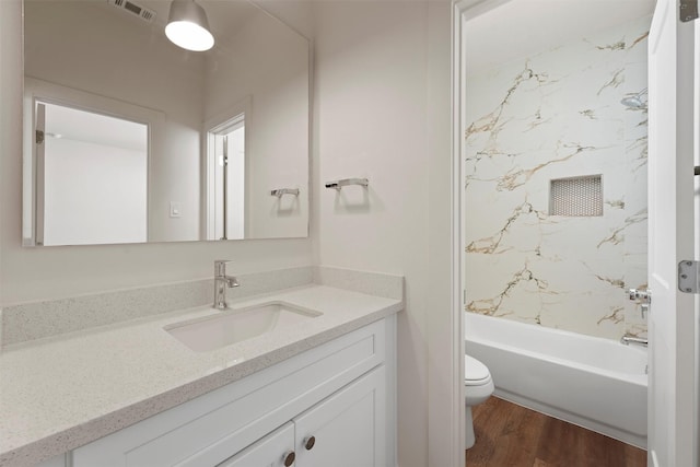 bathroom featuring visible vents, toilet, bathing tub / shower combination, wood finished floors, and vanity