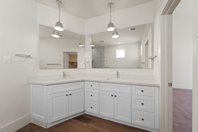 bathroom with visible vents, baseboards, a marble finish shower, and a sink
