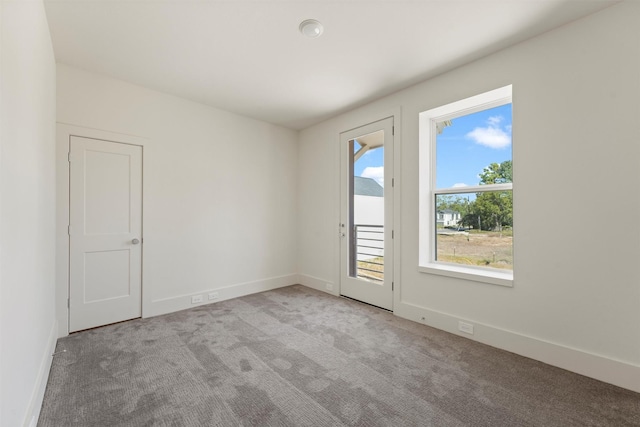 carpeted empty room with baseboards