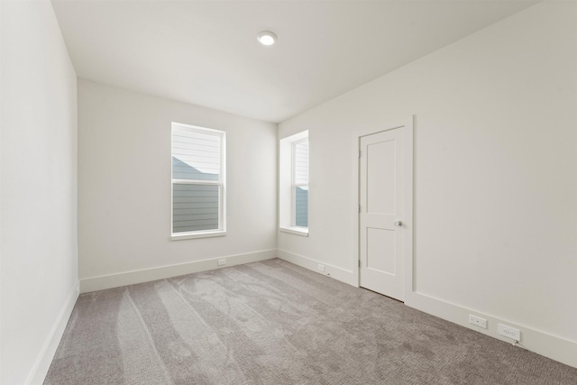 spare room featuring baseboards and carpet floors