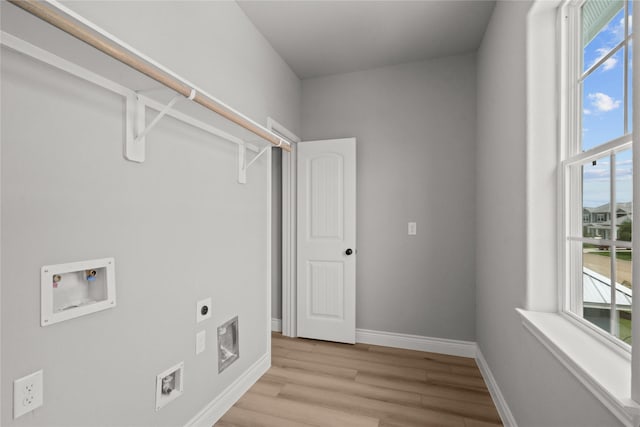 clothes washing area with hookup for a washing machine, laundry area, light wood-style floors, hookup for an electric dryer, and baseboards
