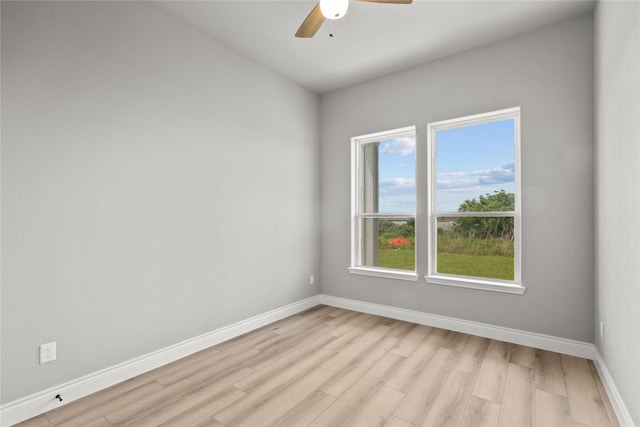 unfurnished room featuring baseboards, a ceiling fan, and light wood-style flooring