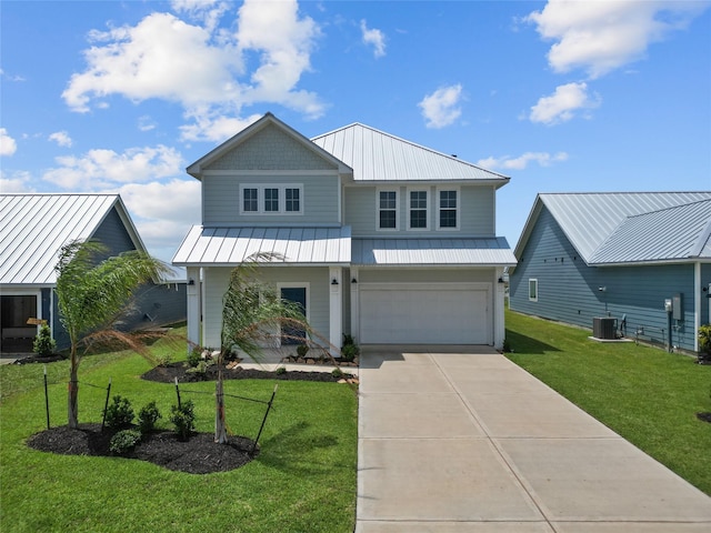 view of front facade featuring a front yard, a standing seam roof, central AC, concrete driveway, and an attached garage