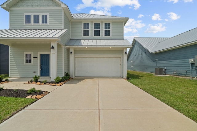 view of front of property featuring a standing seam roof, driveway, a front lawn, and an attached garage