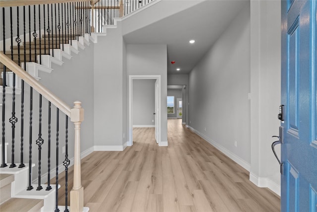 entrance foyer featuring baseboards, stairway, wood finished floors, and recessed lighting