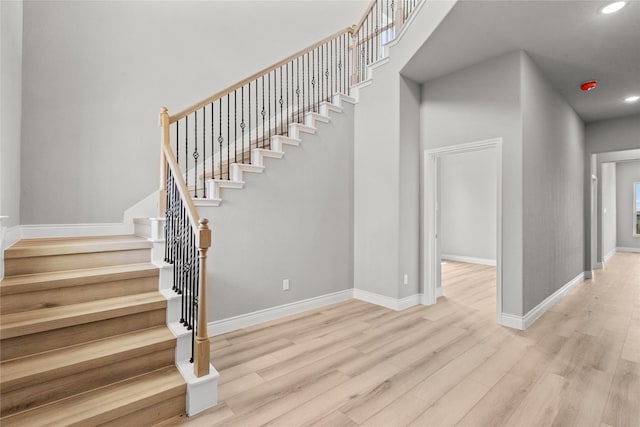 staircase featuring recessed lighting, wood finished floors, and baseboards