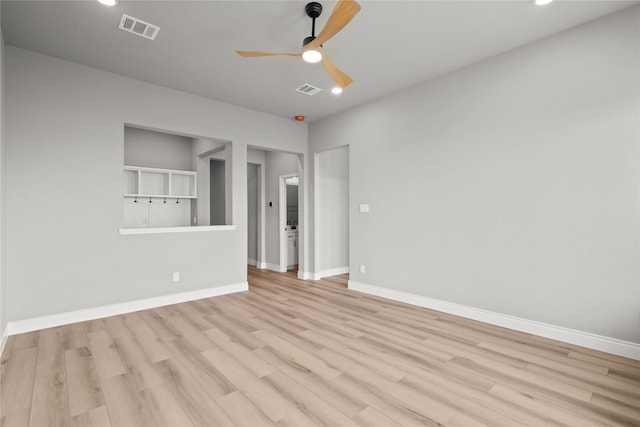 unfurnished room featuring wood finished floors, visible vents, a ceiling fan, and baseboards