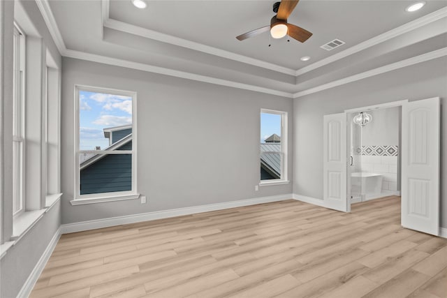 unfurnished bedroom featuring baseboards, visible vents, a raised ceiling, and light wood-style flooring