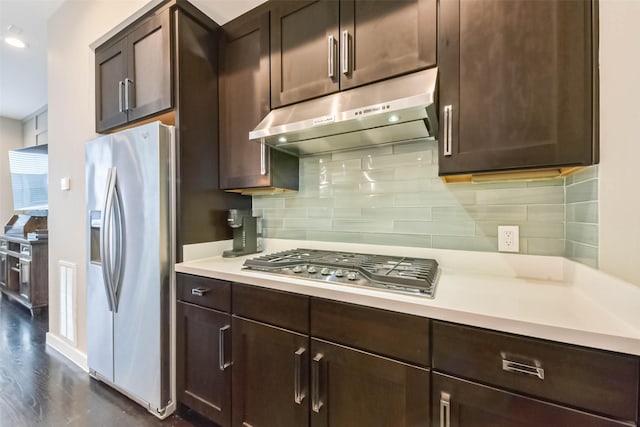 1812 Bingham St, Houston, TX 77007 - kitchen with dark brown cabinetry, tasteful backsplash, under cabinet range hood, appliances with stainless steel finishes, and light countertops