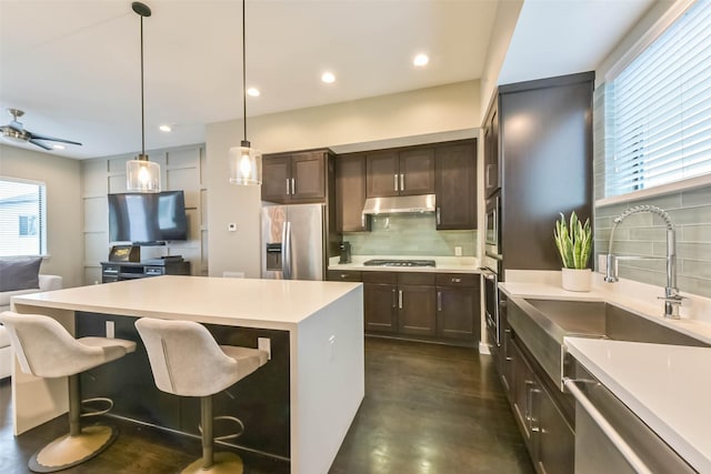 1812 Bingham St, Houston, TX 77007 - kitchen featuring a sink, under cabinet range hood, backsplash, light countertops, and appliances with stainless steel finishes
