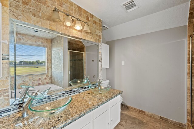 full bathroom featuring vanity, a bath, toilet, a stall shower, and visible vents