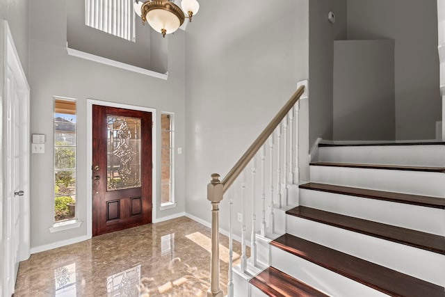 foyer entrance with baseboards, stairway, a high ceiling, and marble finish floor