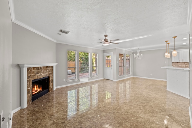 unfurnished living room with visible vents, ornamental molding, ceiling fan with notable chandelier, and a stone fireplace