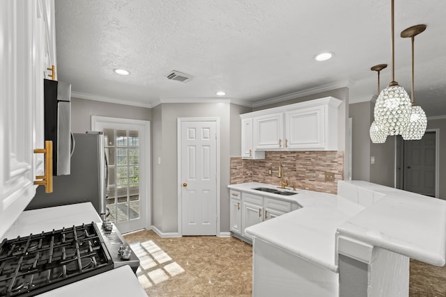 kitchen with a sink, tasteful backsplash, visible vents, a peninsula, and white cabinetry