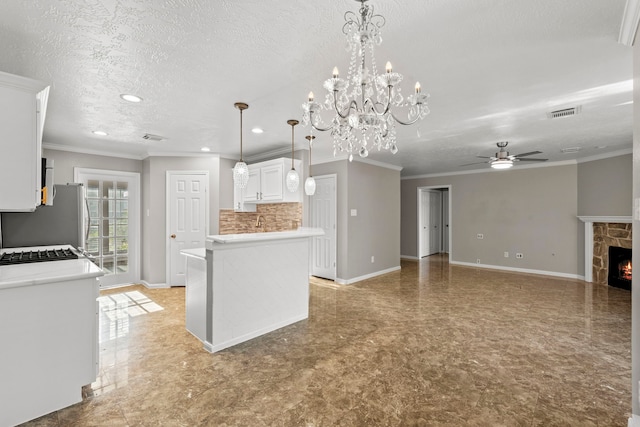 kitchen featuring white cabinets, ceiling fan with notable chandelier, light countertops, and freestanding refrigerator
