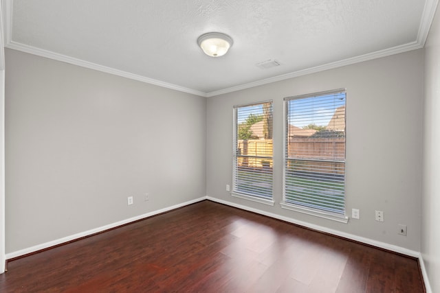 empty room with ornamental molding, dark wood-style flooring, baseboards, visible vents, and a textured ceiling