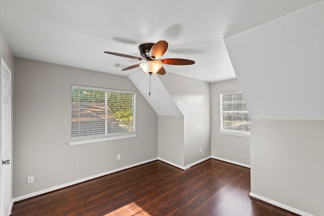 additional living space featuring a ceiling fan, baseboards, wood finished floors, and plenty of natural light