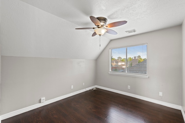 additional living space with visible vents, baseboards, dark wood finished floors, vaulted ceiling, and a ceiling fan