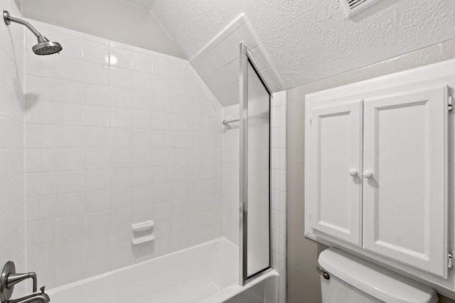 bathroom with toilet, shower / tub combination, vaulted ceiling, and a textured ceiling