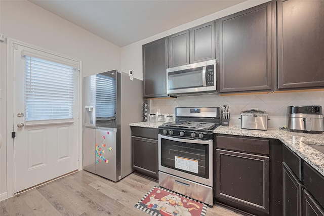 4807 Purple Wisteria Ln, Spring, TX 77373 - kitchen with stainless steel appliances, light wood-style flooring, and tasteful backsplash