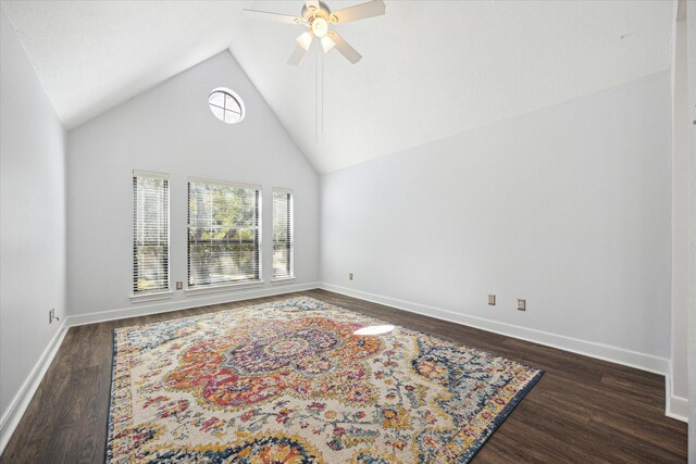 spare room with baseboards, a ceiling fan, dark wood-style flooring, and lofted ceiling
