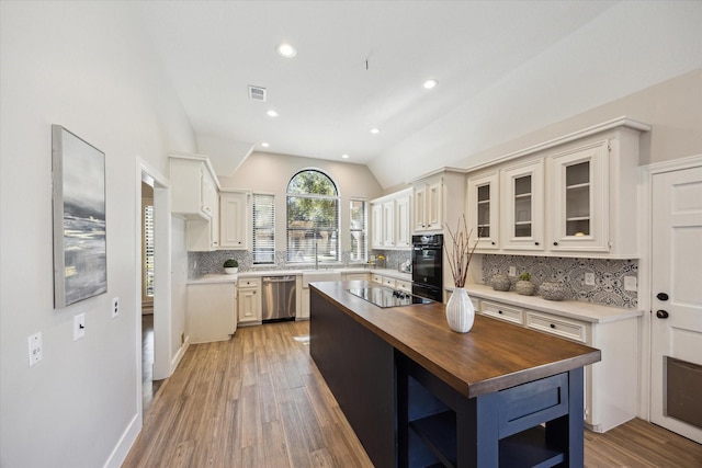 kitchen featuring butcher block countertops, open shelves, tasteful backsplash, black appliances, and vaulted ceiling