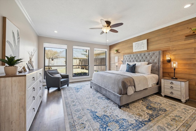 bedroom with wood finished floors, wooden walls, recessed lighting, and ornamental molding