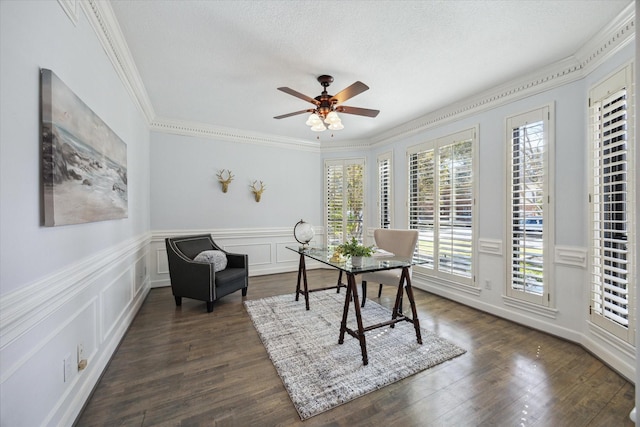 office area featuring ceiling fan, a wainscoted wall, ornamental molding, dark wood finished floors, and a decorative wall
