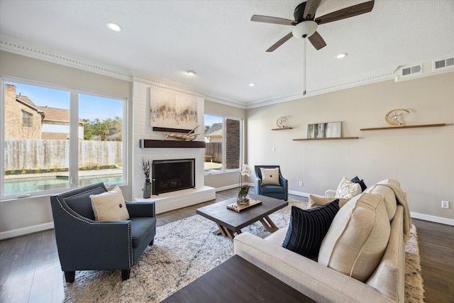 living room with a large fireplace, a healthy amount of sunlight, a ceiling fan, and baseboards