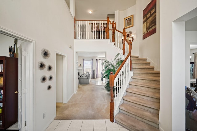 13823 Eldridge Garden Cir, Houston, TX 77083 - entrance foyer with carpet, baseboards, stairs, tile patterned flooring, and a towering ceiling