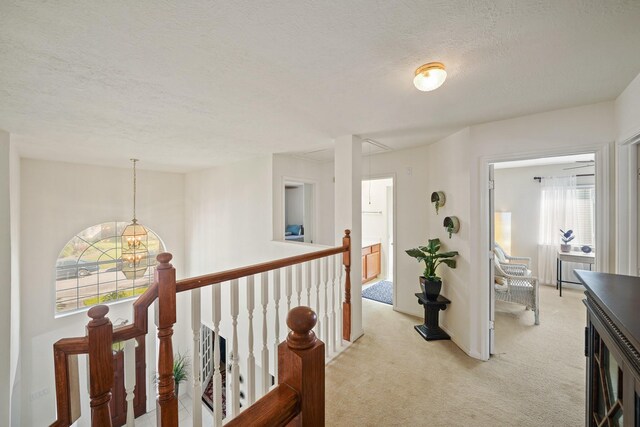 13823 Eldridge Garden Cir, Houston, TX 77083 - corridor featuring a chandelier, a textured ceiling, light carpet, and an upstairs landing
