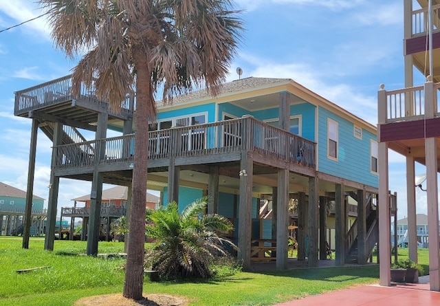 back of property featuring a lawn and a deck