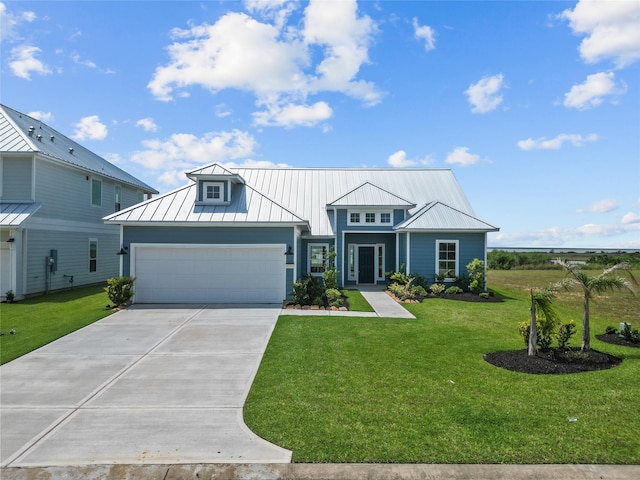 view of front facade with an attached garage, driveway, a front yard, and a standing seam roof
