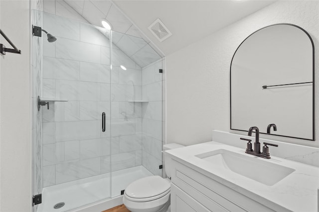 bathroom featuring vanity, a shower stall, toilet, and visible vents