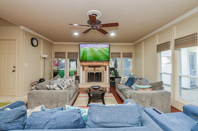 living room featuring a fireplace with raised hearth, ornamental molding, ceiling fan, and recessed lighting