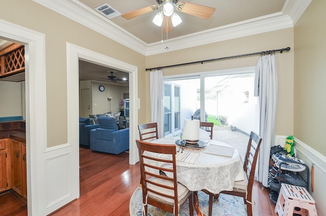 dining area with wood-type flooring, ceiling fan, and ornamental molding
