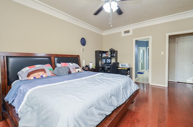 bedroom with a ceiling fan, visible vents, wood finished floors, baseboards, and ornamental molding
