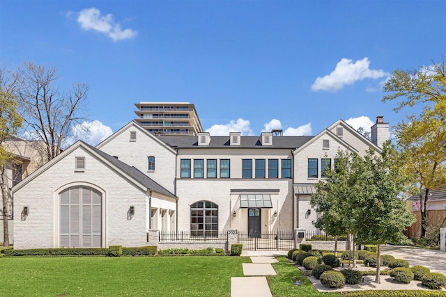 2023 Drexel Dr, Houston, TX 77027 - rear view of house featuring a lawn, a chimney, brick siding, and a fenced front yard