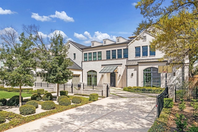 2023 Drexel Dr, Houston, TX 77027 - view of front facade with metal roof, a standing seam roof, a fenced front yard, and brick siding