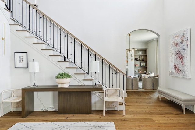 2023 Drexel Dr, Houston, TX 77027 - staircase with baseboards, arched walkways, ornamental molding, wood finished floors, and a high ceiling