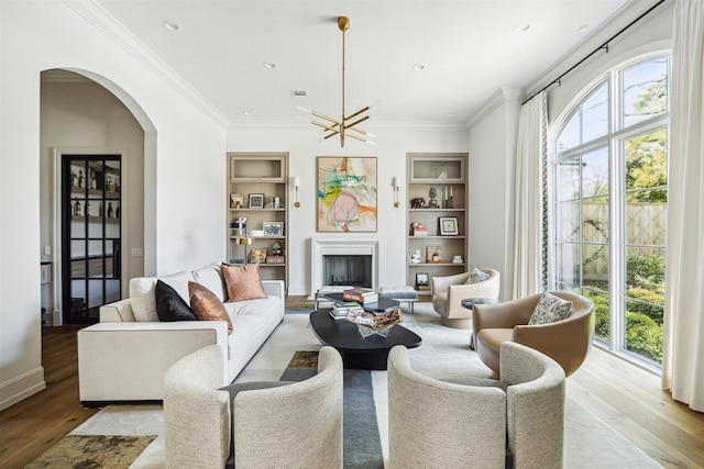 2023 Drexel Dr, Houston, TX 77027 - living area featuring wood finished floors, a healthy amount of sunlight, built in features, and arched walkways