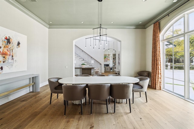 2023 Drexel Dr, Houston, TX 77027 - dining room featuring stairway, arched walkways, hardwood / wood-style flooring, and crown molding