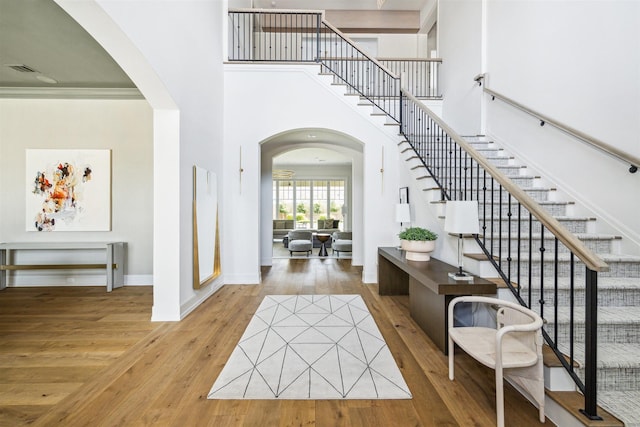 2023 Drexel Dr, Houston, TX 77027 - entryway with arched walkways, hardwood / wood-style flooring, baseboards, stairway, and a towering ceiling