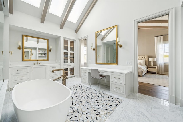 2023 Drexel Dr, Houston, TX 77027 - bathroom with vaulted ceiling with skylight, vanity, connected bathroom, marble finish floor, and a freestanding bath
