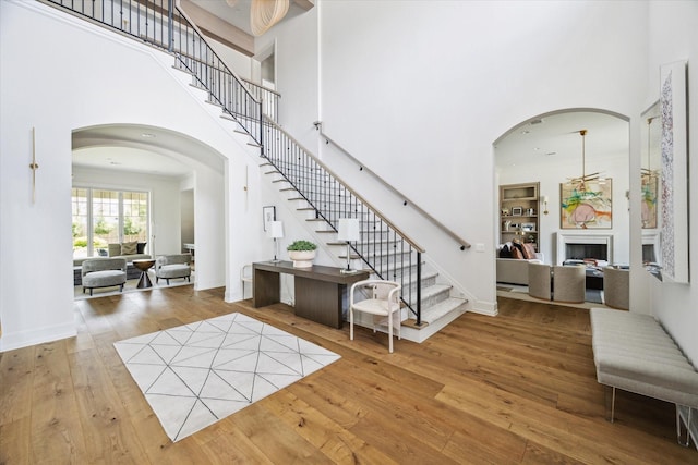 2023 Drexel Dr, Houston, TX 77027 - foyer entrance featuring stairs, a high ceiling, wood finished floors, and arched walkways