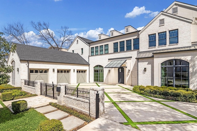 2023 Drexel Dr, Houston, TX 77027 - townhome / multi-family property featuring driveway, a fenced front yard, an attached garage, and brick siding